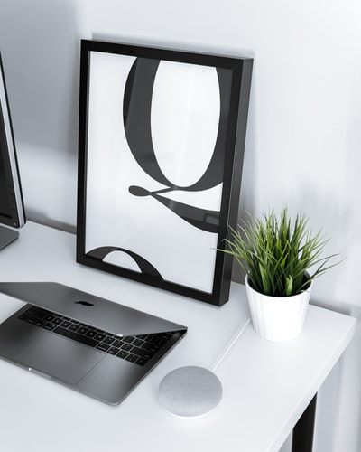 The MacBook Air and Google Home mini white the surface of the table
